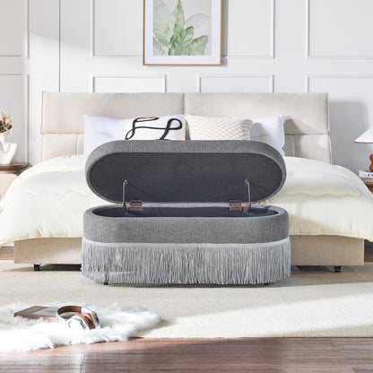 Oval Upholstered Storage Ottoman with Fringe Trim